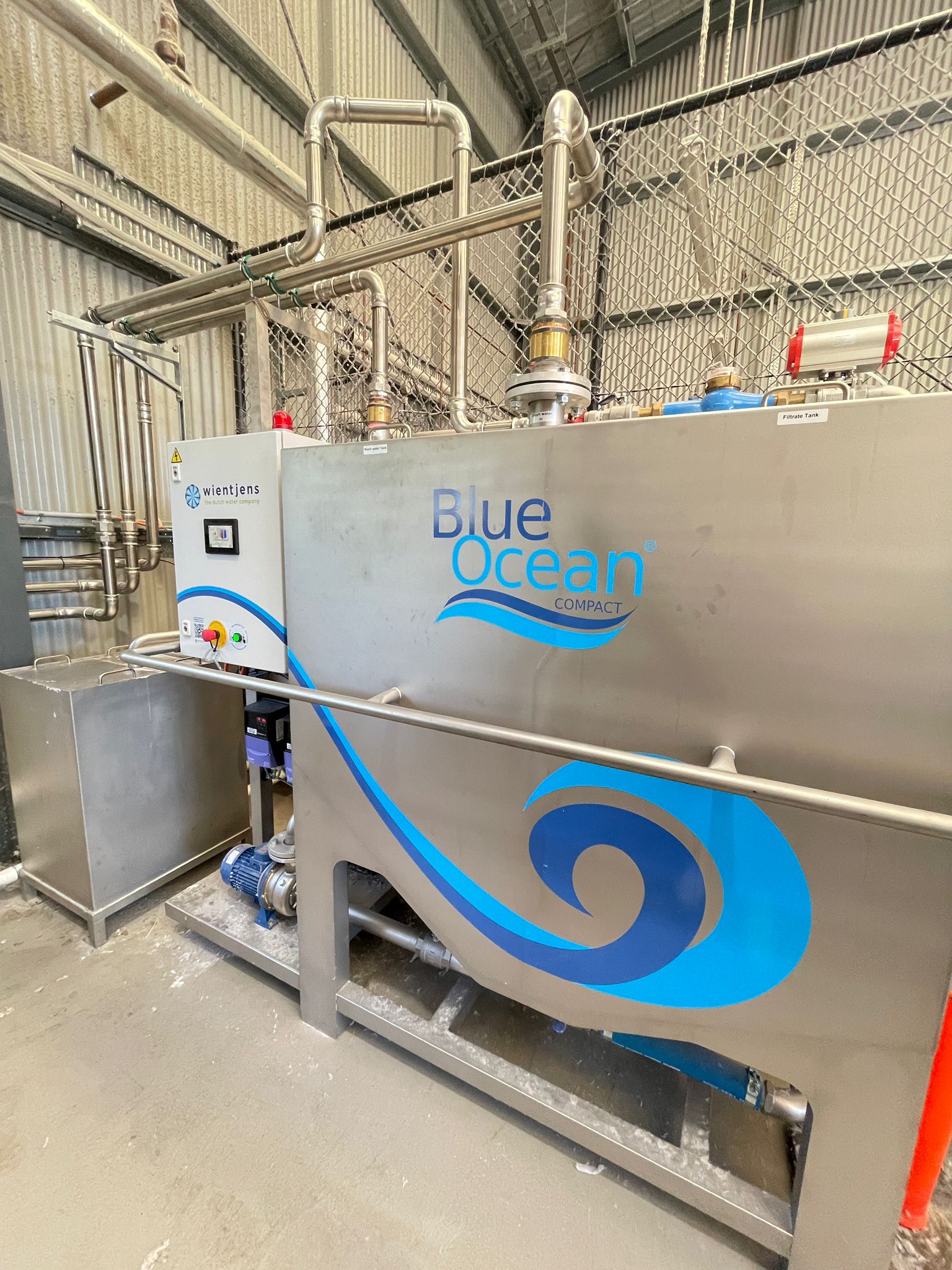 Blue Ocean Compact and AquaDrain water recovery system installed in a high-volume commercial laundry facility processing 50+ tonnes weekly - professional installation with existing infrastructure